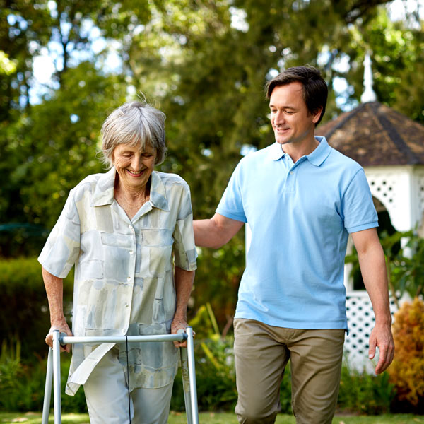 man helping senior woman use walker