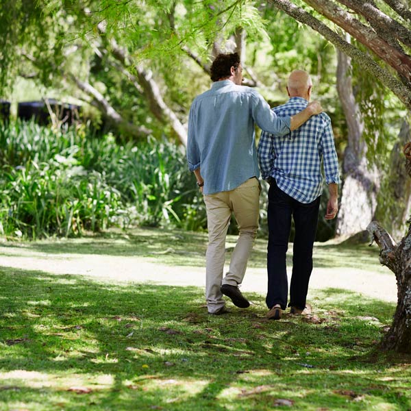 senior man and son walking in wooded area